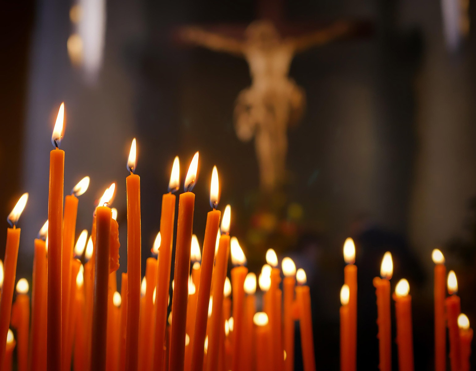 Levande ljus tända i en kyrka.