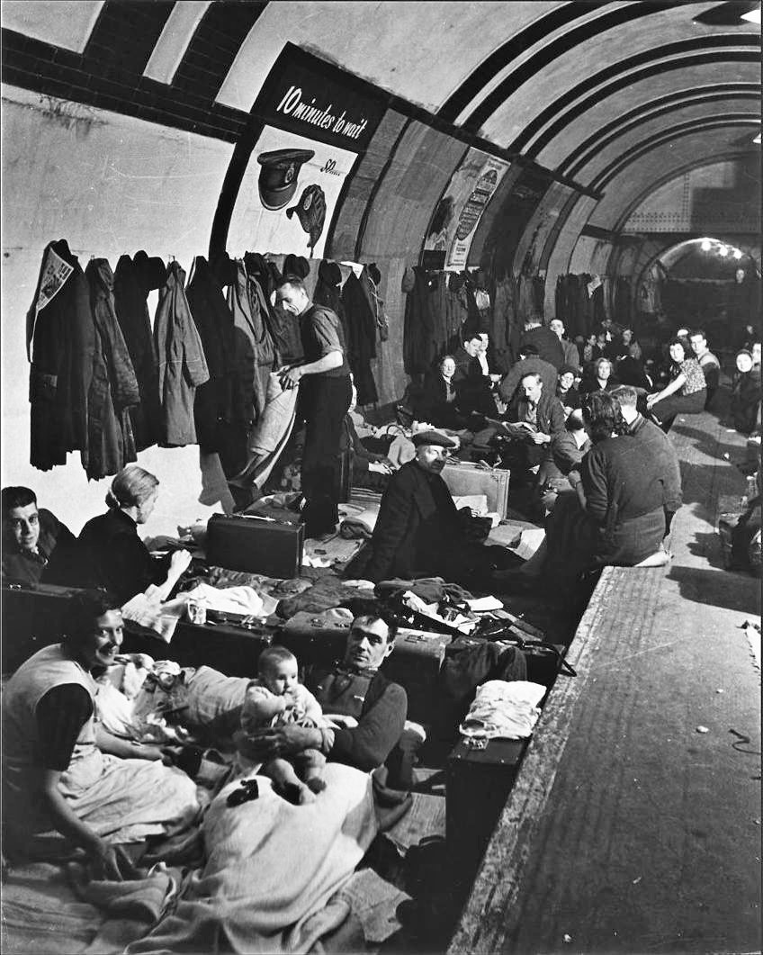 Skyddsrum av tunnelbanan. Folk sitter och ligger överallt, till och med på spåren.