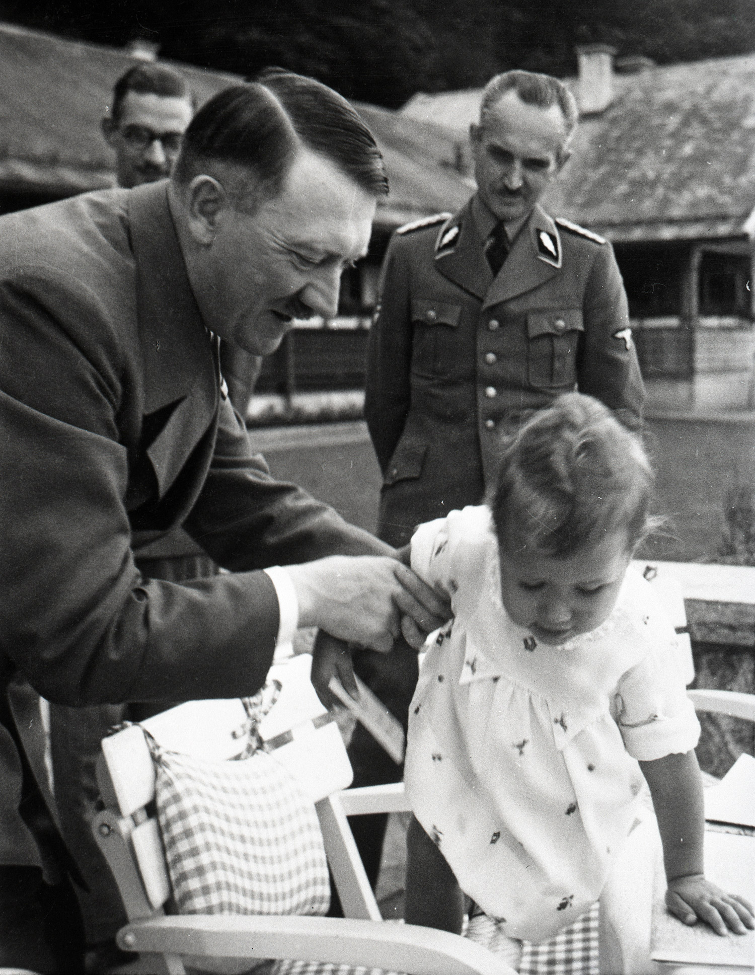 Hitler hjälper en liten flicka på 1,5 år att klättra upp ur en barnstol.