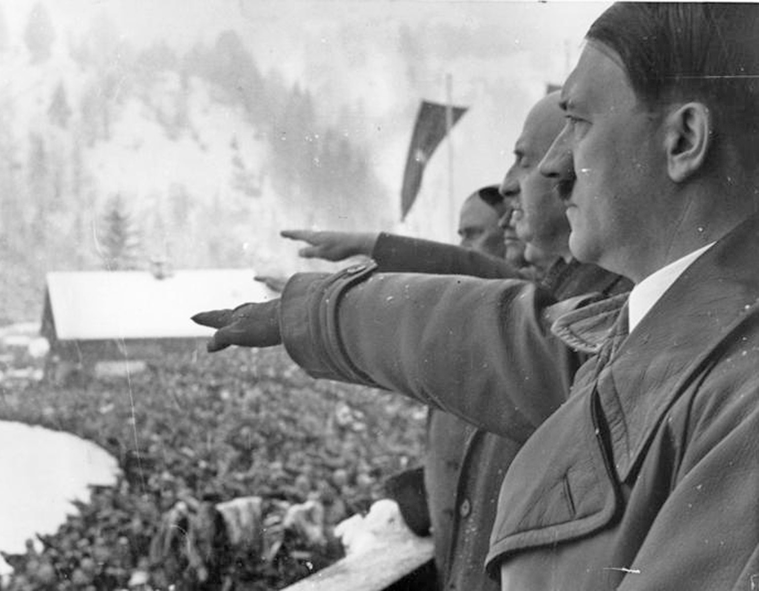 Hitler och andra nazipampar hailar på vip-läktaren. 