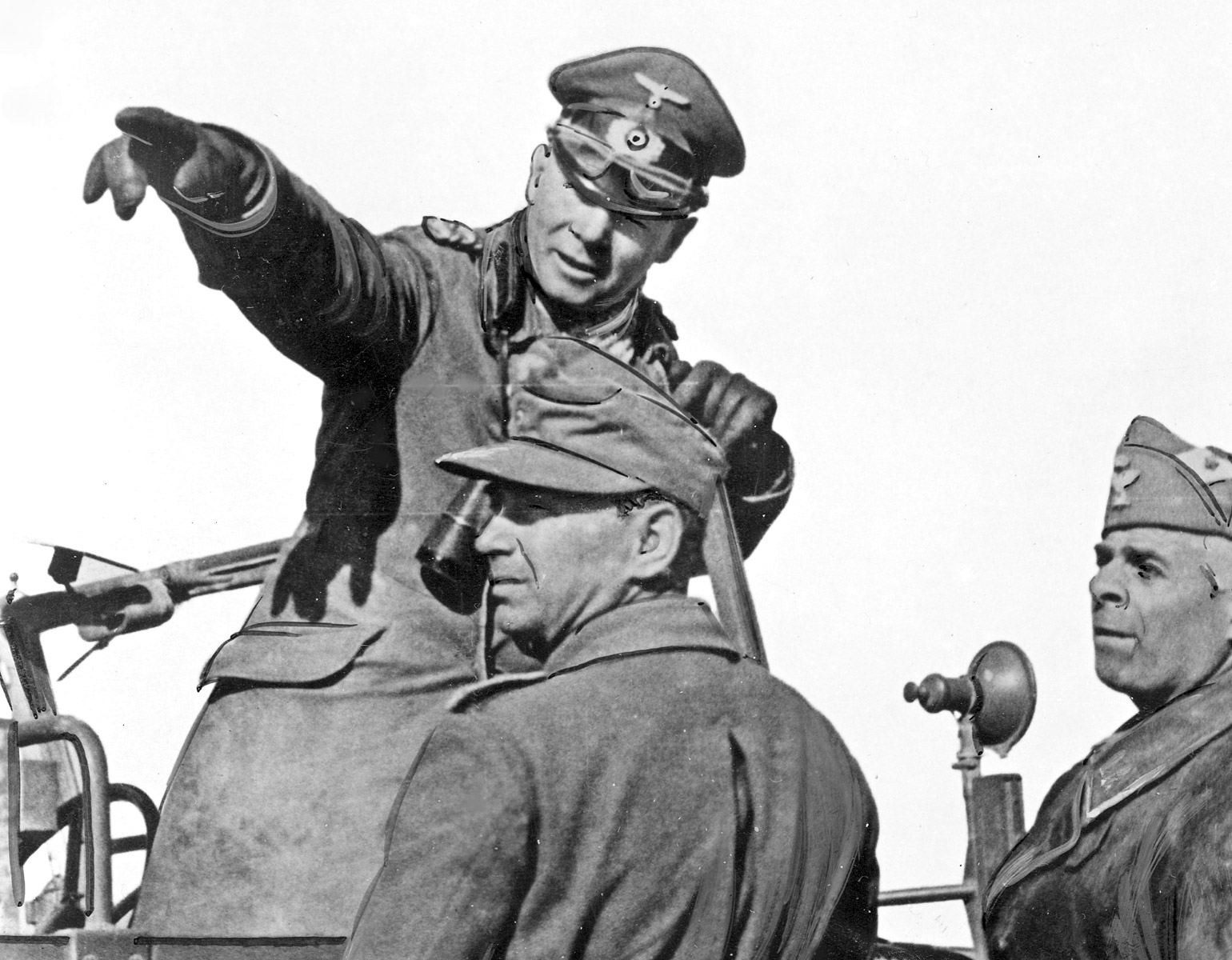 Rommel står i ett militärfordon och pekar mot något.
