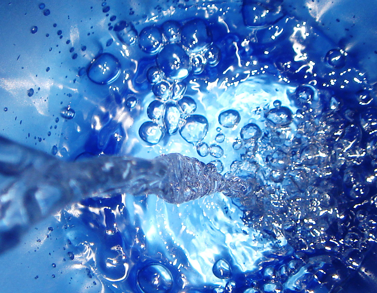 VAtten som hälls ner i vatten - bubblor uppstår. 