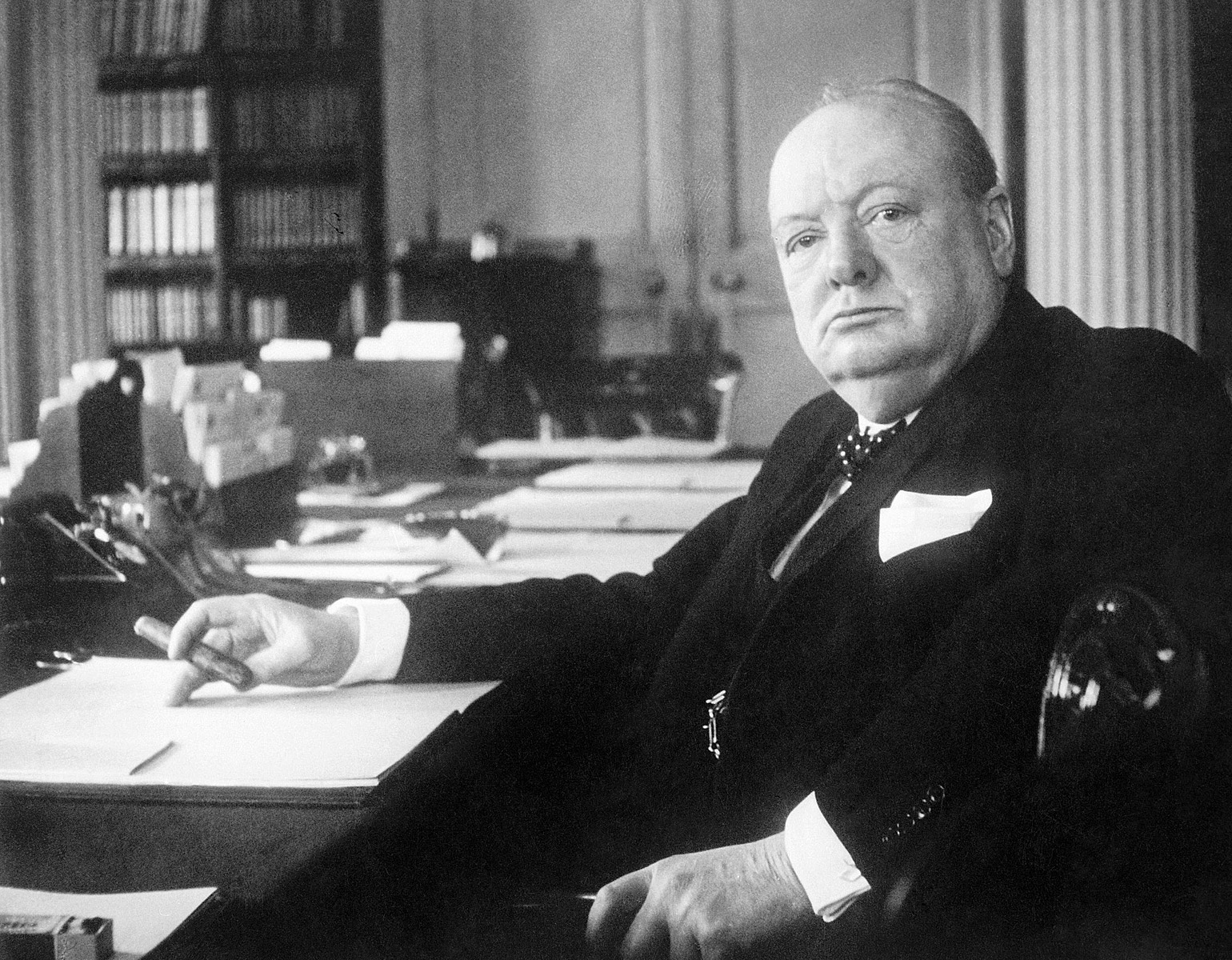 Churchill sittandes vid ett skrivbord.