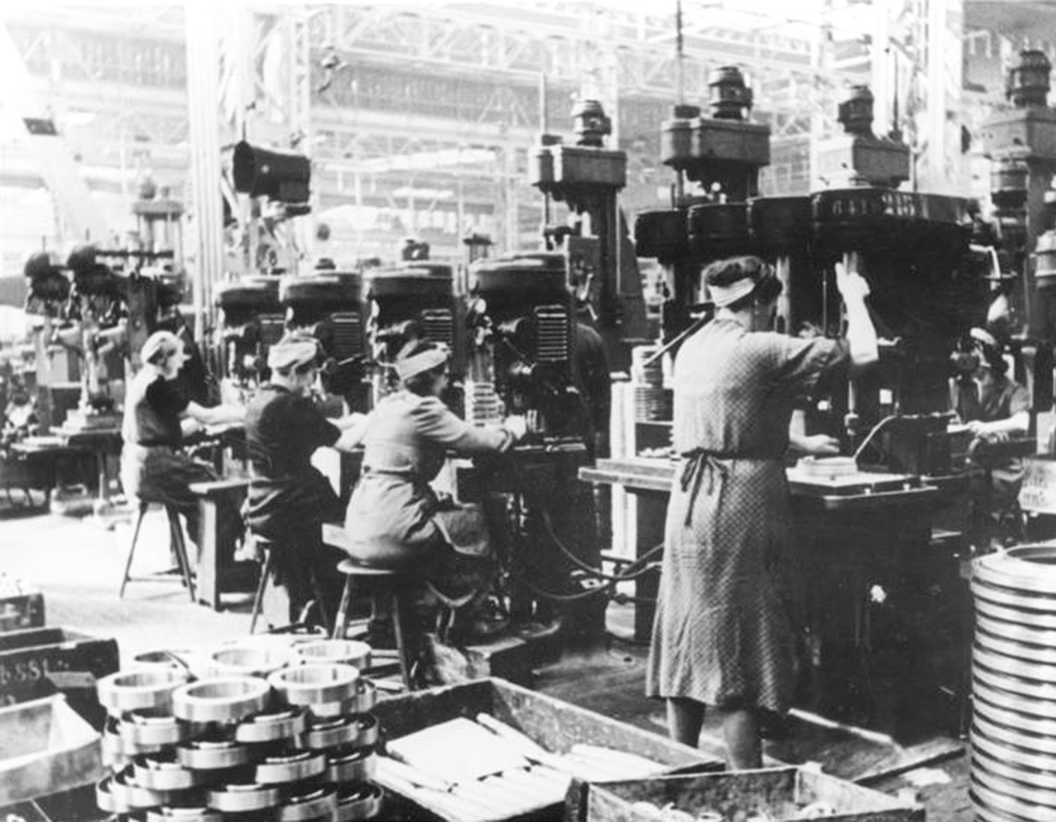 Kvinnliga industriarbetare vid maskiner i en fabrik.