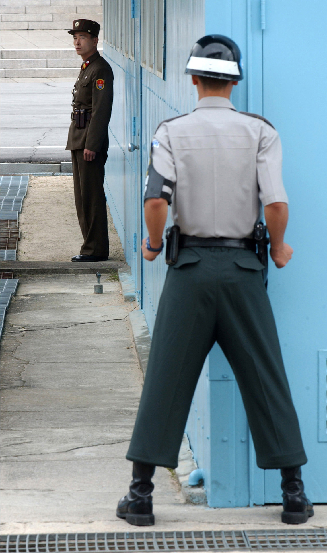 En sydkoreansk och en nordkoreansk vakt på varsin sida gränsen (den demilitäriserade zonen).
