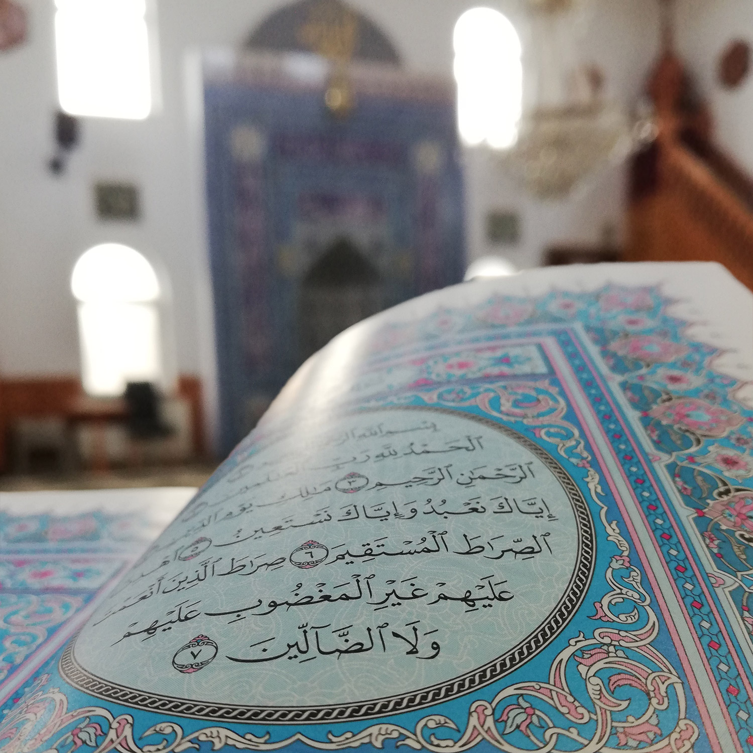 En uppslagen vackert illustrerad koran i en moské.