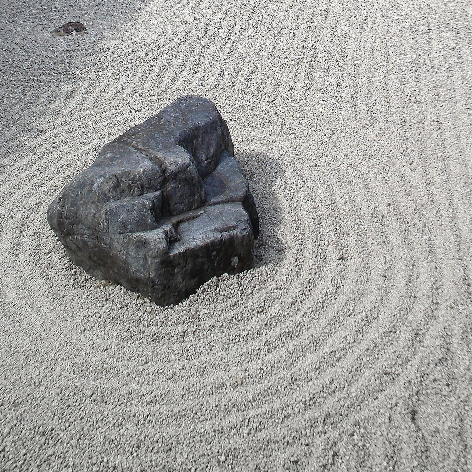 En strikt krattad grusgång med några större stenar som utgör öar.