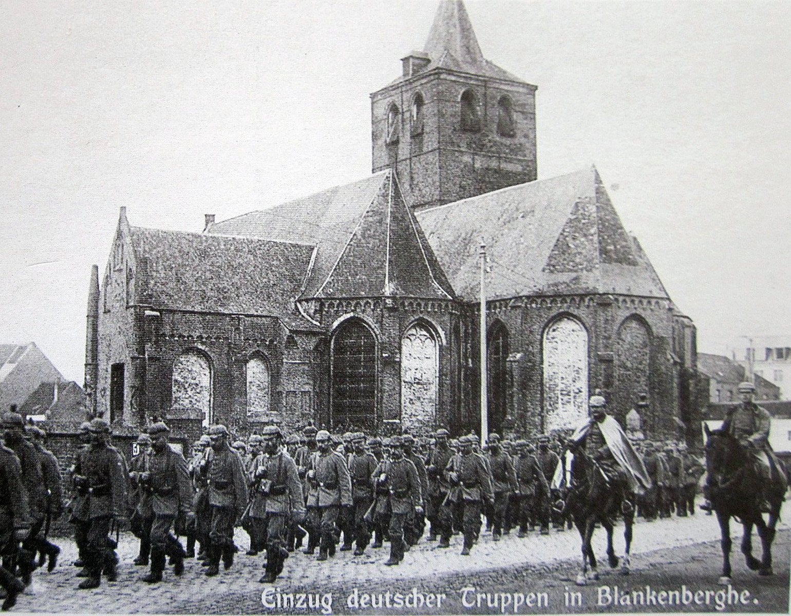 Tyska soldater marscherar förbi en belgisk kyrka.