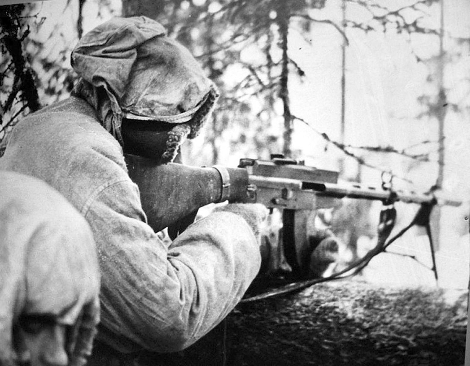 En finsk ksp-skytt i ett skyttevärn i vinterlandskap.