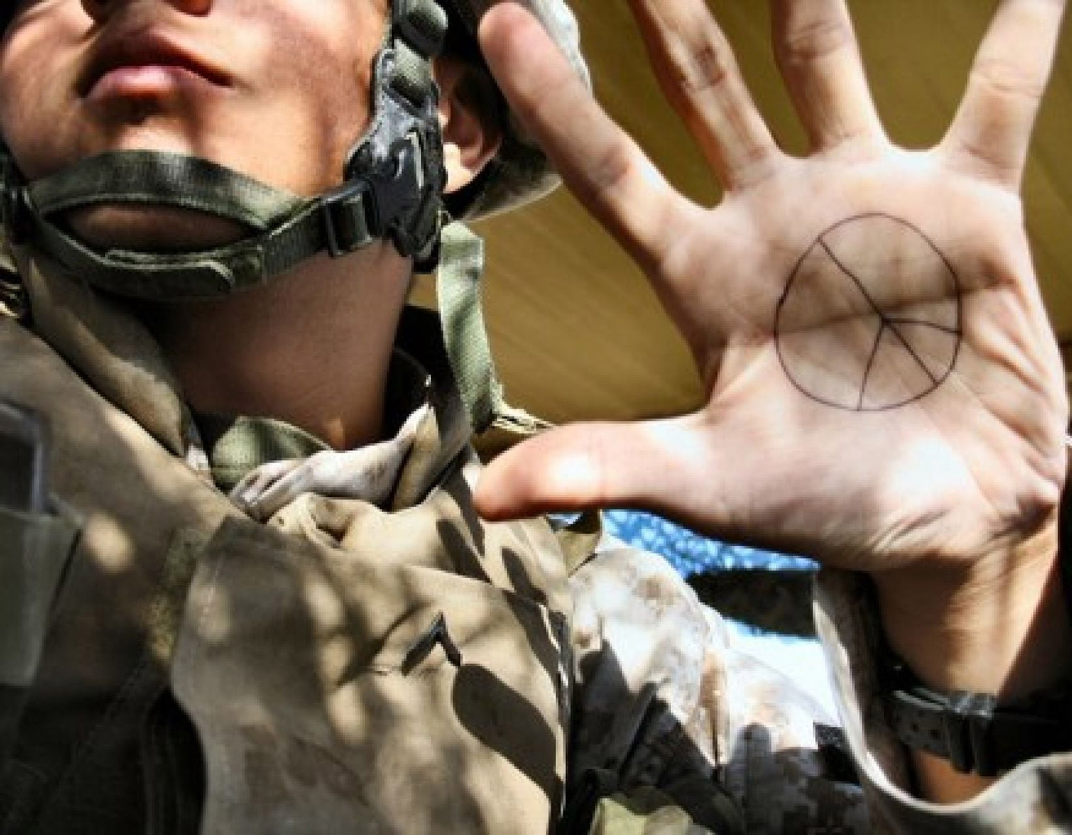 Militär med ett fredstecken i handflatan.