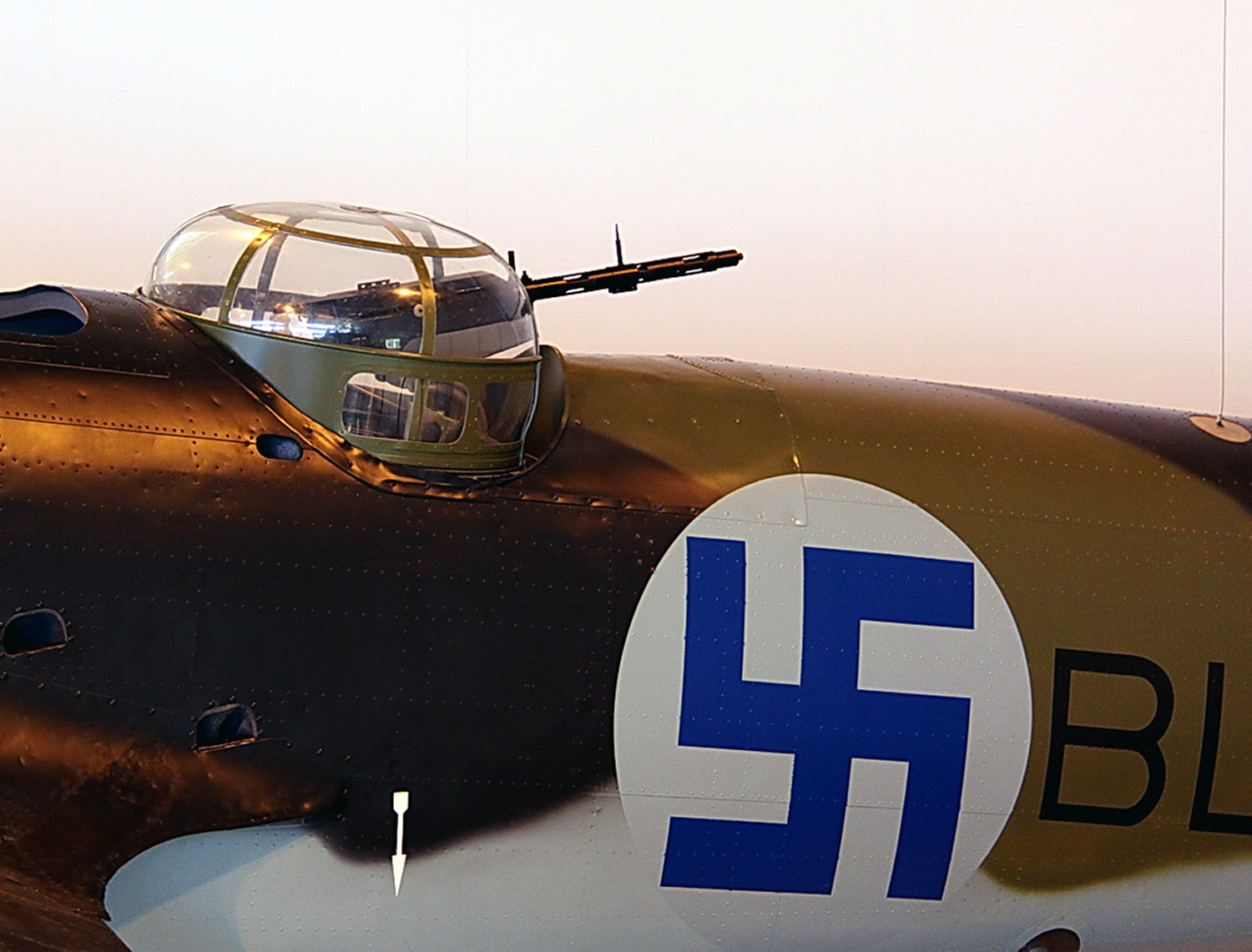 Flygplanskropp med ett målat hakkors i blått mot vit bakgrund.