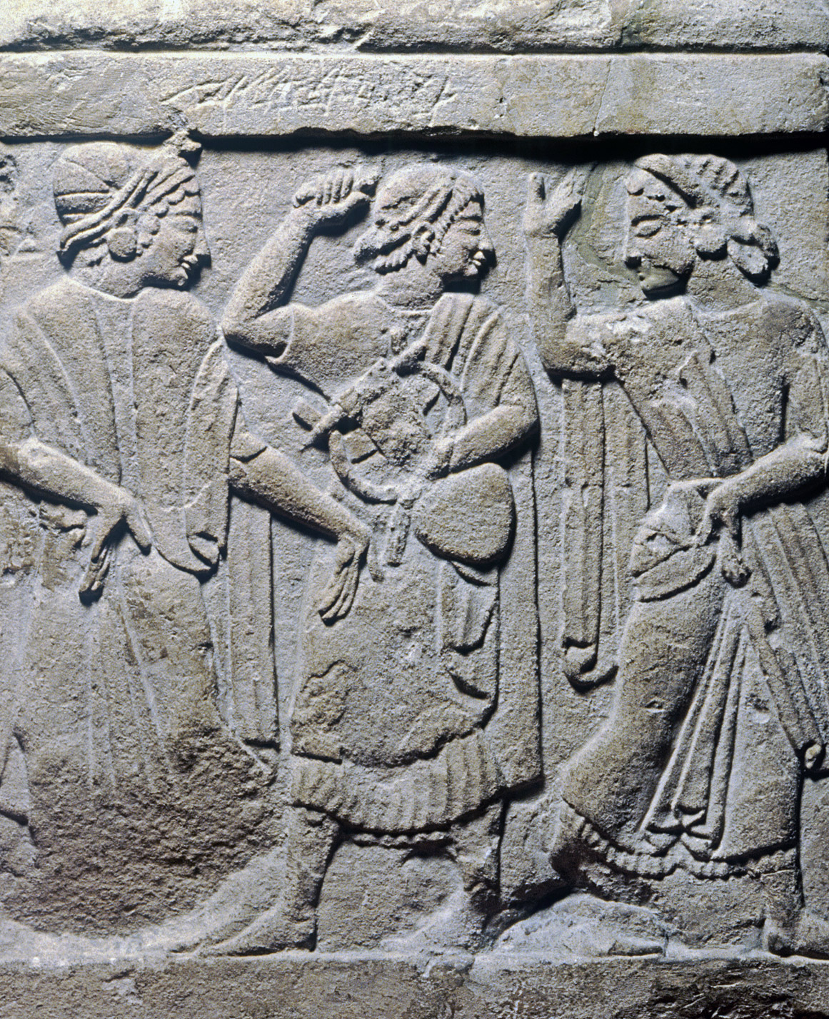 Tre kvinnor avbildade på en gravsten.