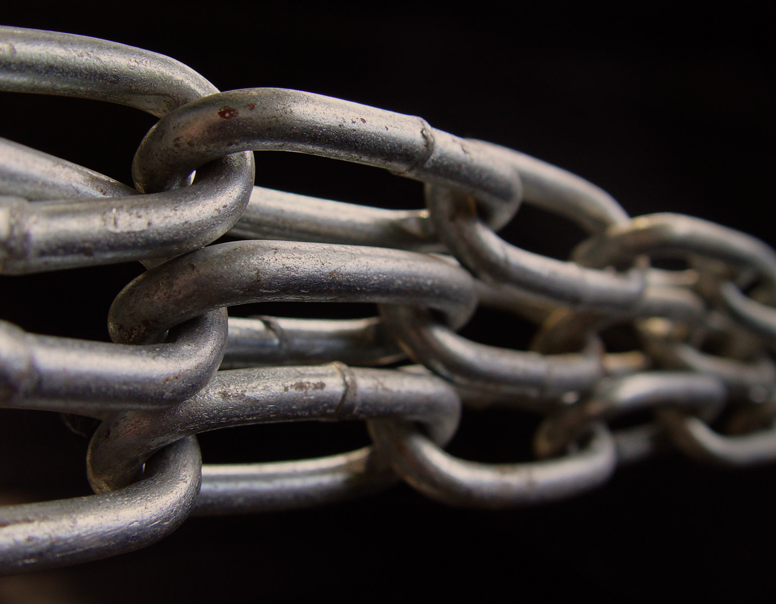 Grova kedjor (kättingar) mot svart bakgrund.