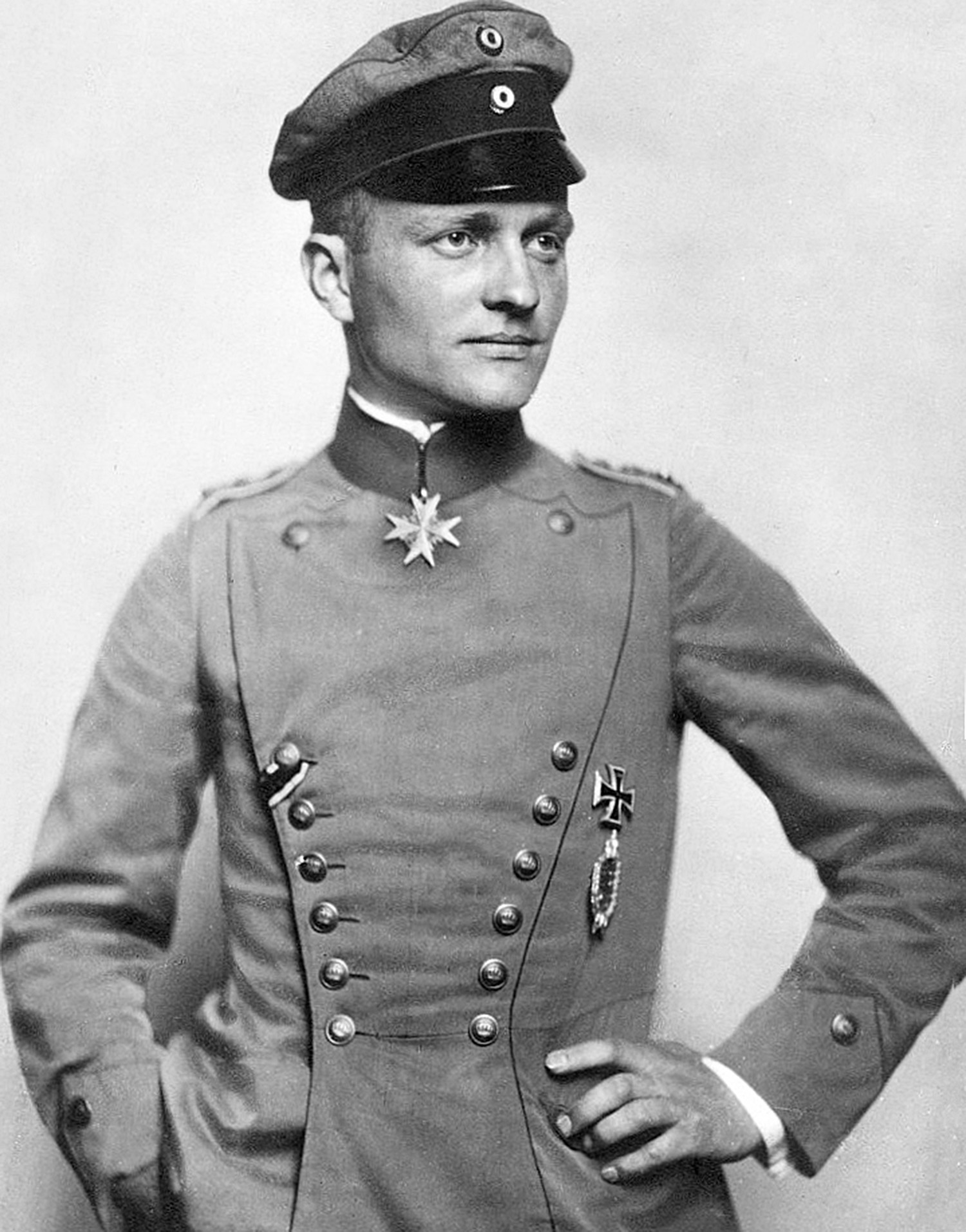 En ung man poserar i uniform.