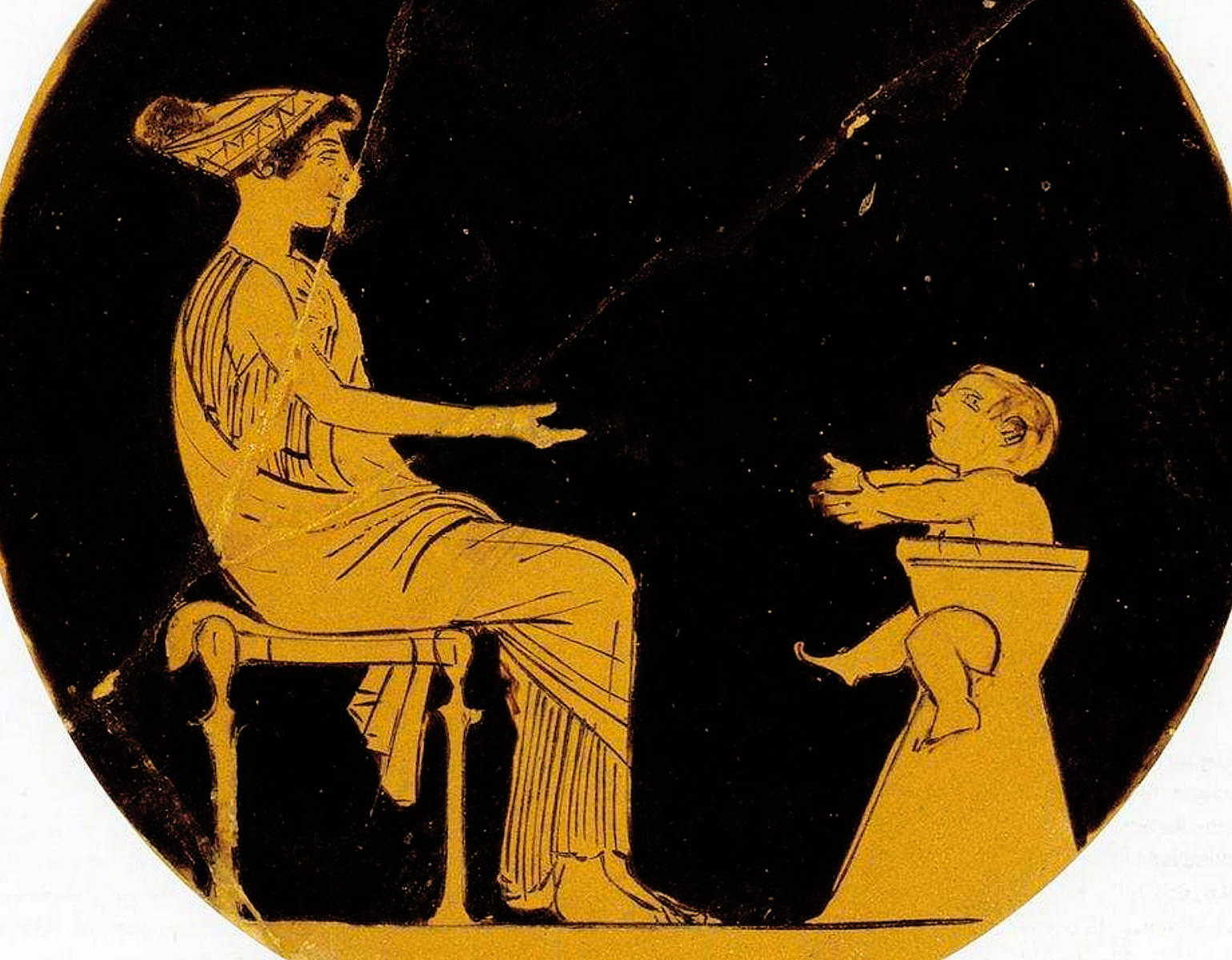 En mamma med sin lilla pojke som sitter på pottan.