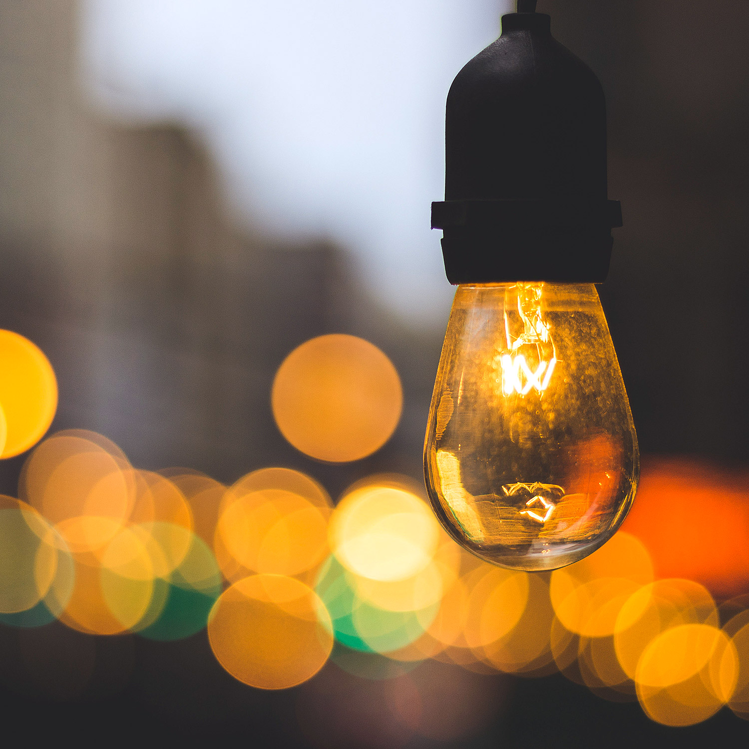 En närbild på en glödlampa utomhus i skymning.