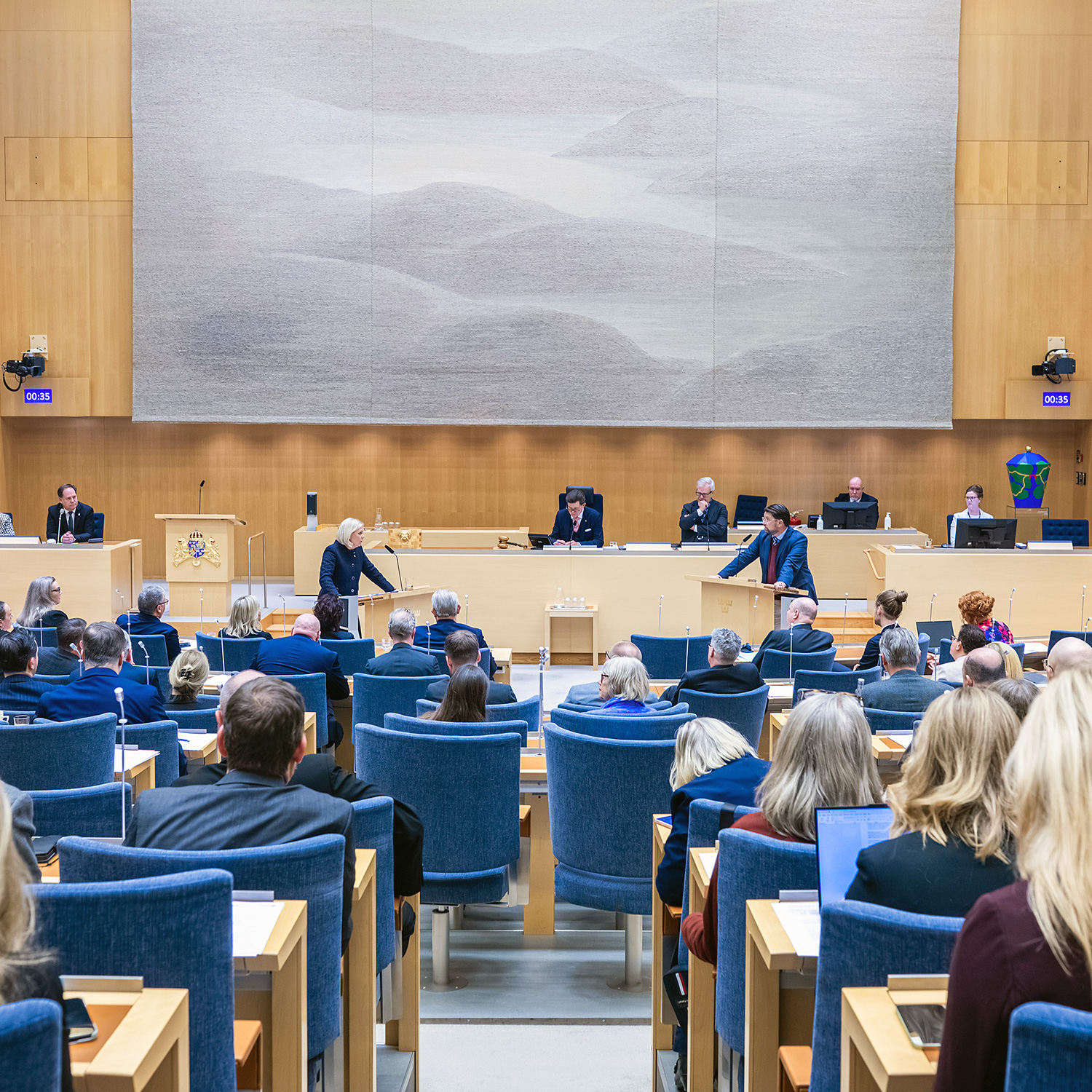 Partiledardebatt 14 januari 2026. Magdalena Andersson (S) i debatt med Jimmie Åkesson (SD). I förgrunden flera ledamöter. 