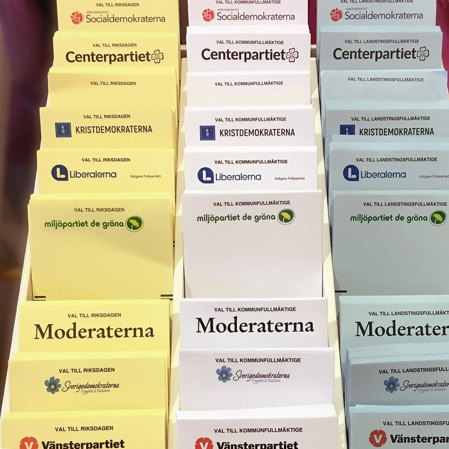 Valsedlar i tre färger uppställda i en trälåda med fack.