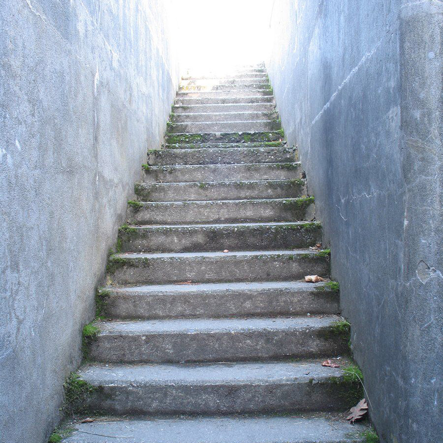Trappa som leder upp mot en öppning med ett starkt ljus.